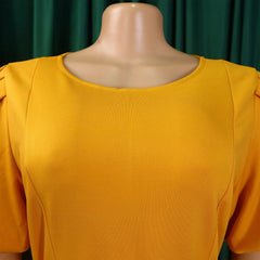 A mustard yellow short-sleeved dress with a round neckline on a mannequin.