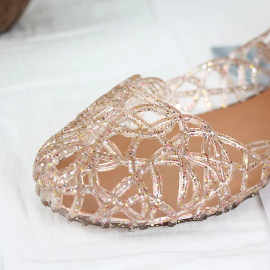 Showlu Fashion women's crystal jelly flat Roman beach sandals with transparent straps and decorative crystal accents.