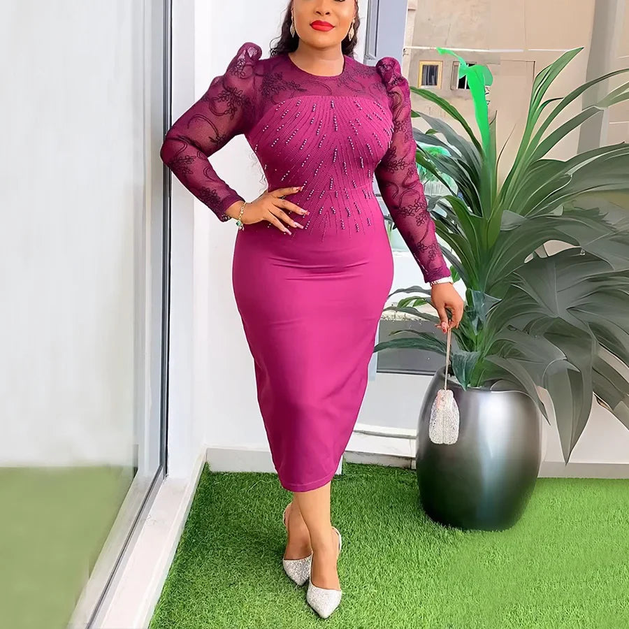 A woman wears a magenta midi-length sheath dress with long lace sleeves and beaded embellishments.
