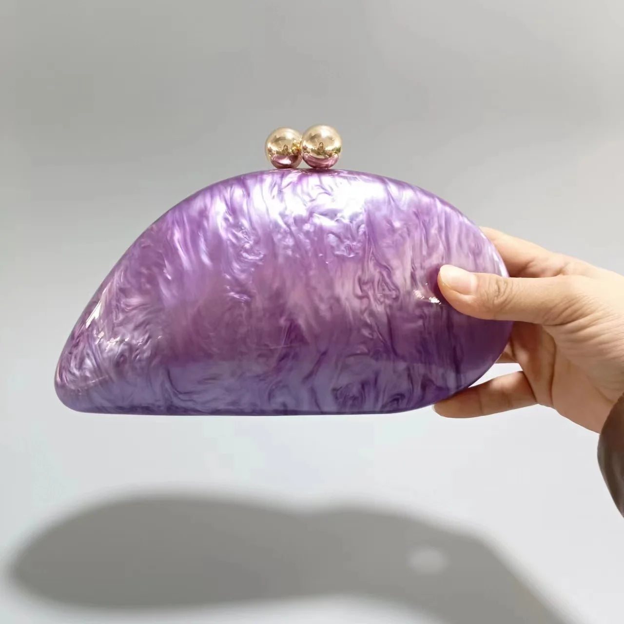 Blue acrylic shell-shaped clutch bag for women, designer evening purse with pearl accents and compact, stylish design.