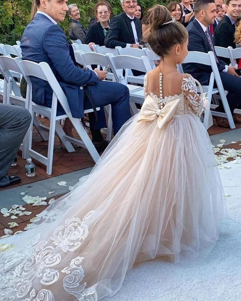 White ivory lace long sleeve flower girl dress with tulle skirt and bow, perfect for weddings and first communions, by Showlu Fashion.
