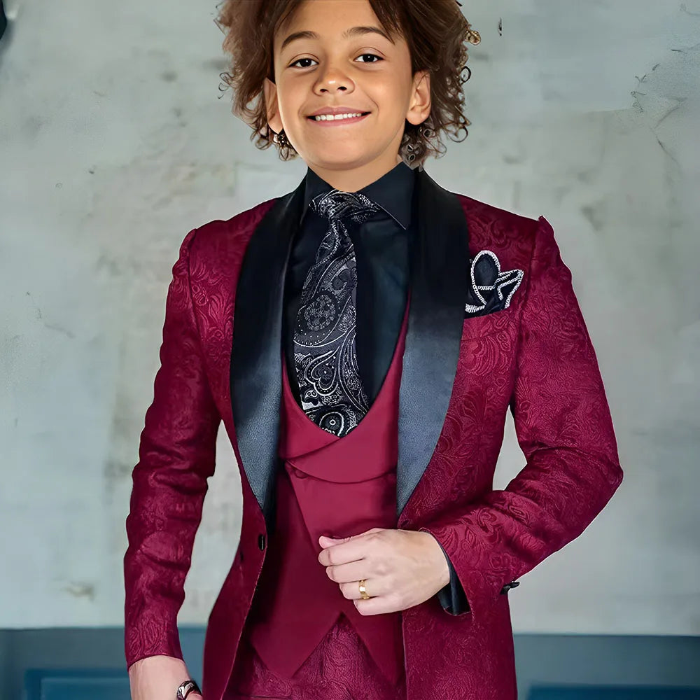 Burgundy jacquard boys' 3-piece suit with jacket, pants, and vest, formal tuxedo style for kids, slim fit, perfect for weddings or special occasions.