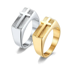 Two stainless steel men's rings, one silver and one gold, featuring a raised cross and sunburst.