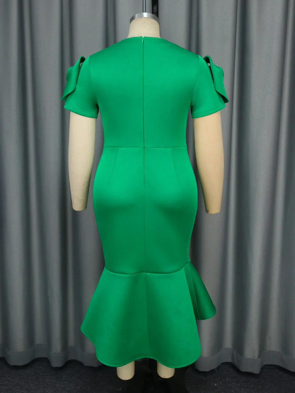 A woman wearing the AOMEI Women's Retro Green Rose Midi Dress, slim fit sheath style, showcasing floral pattern and elegant design.