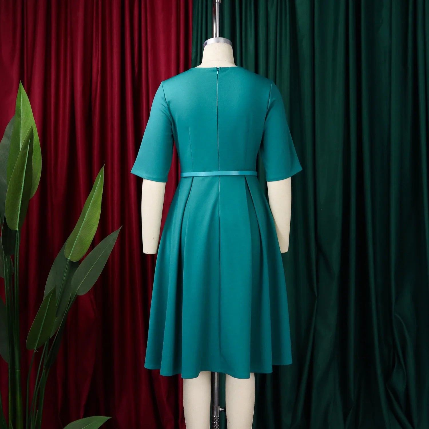 Elegant women's office dress with V-neck, half sleeves, belt, and pleated mid-calf length for professional work attire.