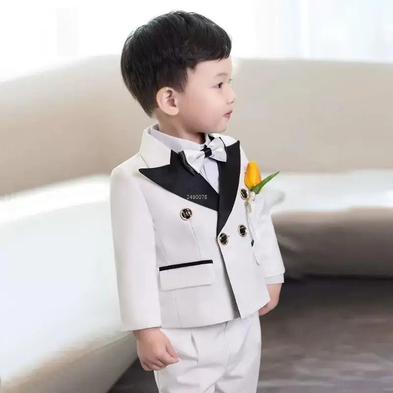 Boy wearing a white wedding tuxedo suit with jacket and pants, designed by SHOWLU FASHION STORE, for formal occasions.