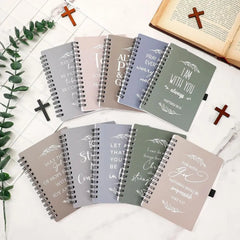 A collection of ten spiral-bound notebooks featuring various Christian Bible verses on the covers.