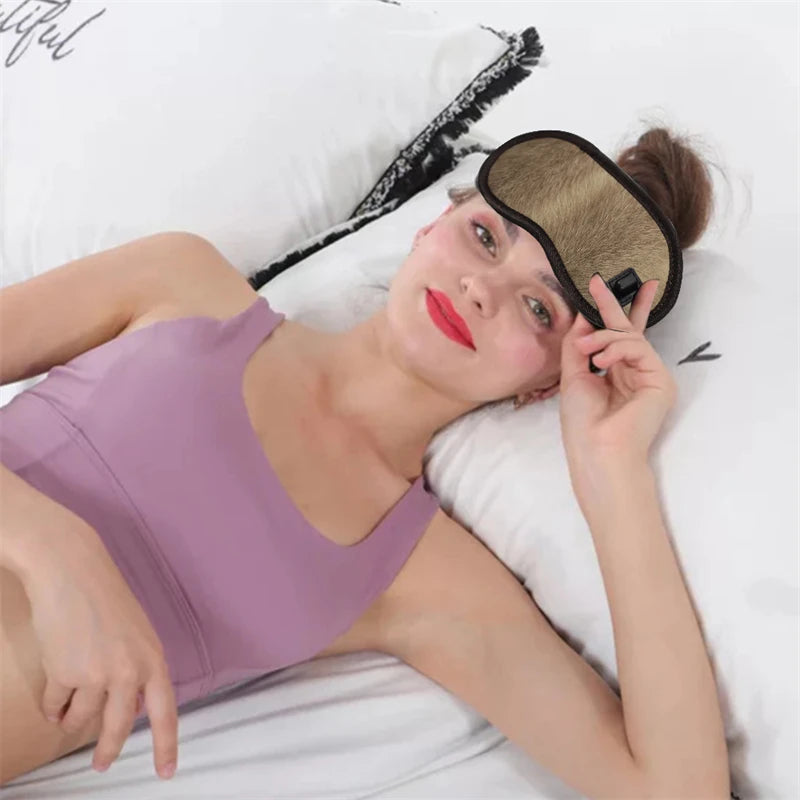 Showlu Smart General Maelsrom Electric Heat Eye Massage Mask resting on a bedside table, showing its sleek design and adjustable strap.