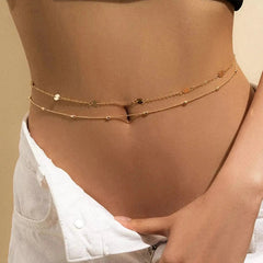 A close-up of a person’s midriff wearing the Sexy Vintage Aesthetic Belly Chain Thin Beads Link Body Chain Waist Chain Belt Y2K Streetwear Summer Women Fashion Body Jewelry with unbuttoned white pants, set against a neutral background.