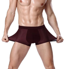 A man wearing dark maroon breathable mesh boxer shorts with a solid front panel.