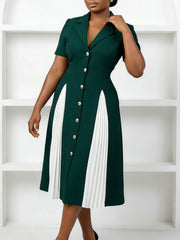 A dark green knee-length dress with a notched collar, short sleeves, and white pleated panels.