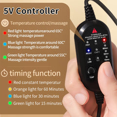A hand holds a black wired controller for a heated eye massager with temperature and timer settings.