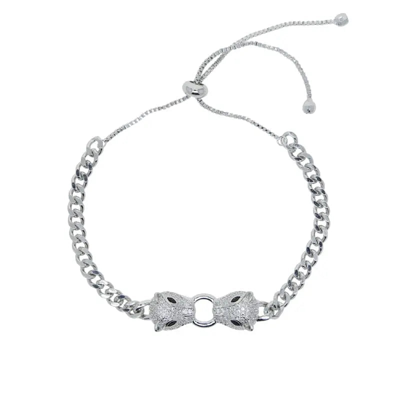 Silver and gold-tone Cuban link bracelet featuring double jaguar head charms with black and white CZ stones, adjustable for women.