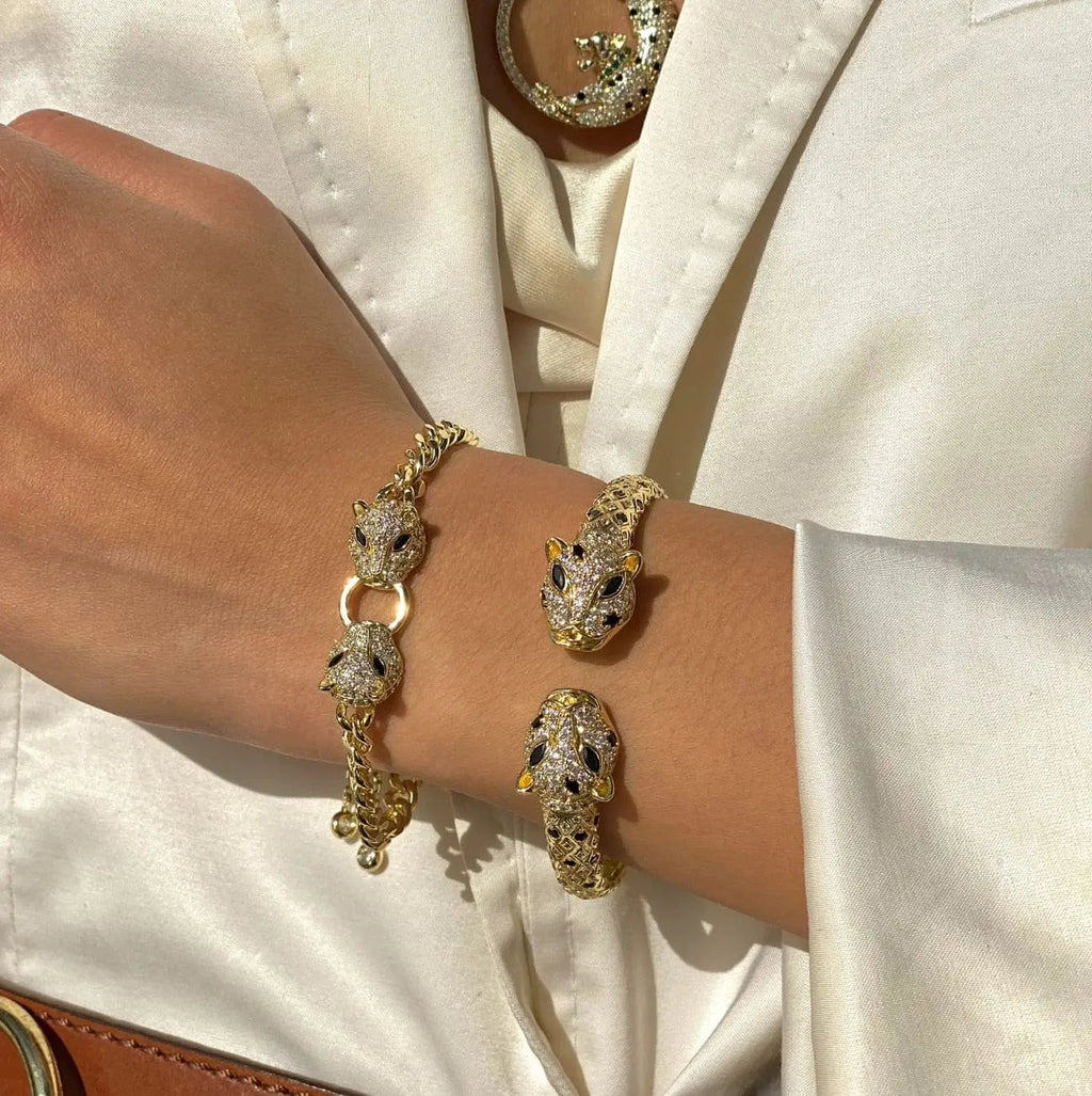 Silver and gold-tone Cuban link bracelet with double jaguar head charms and CZ stones for women, adjustable and stylish.