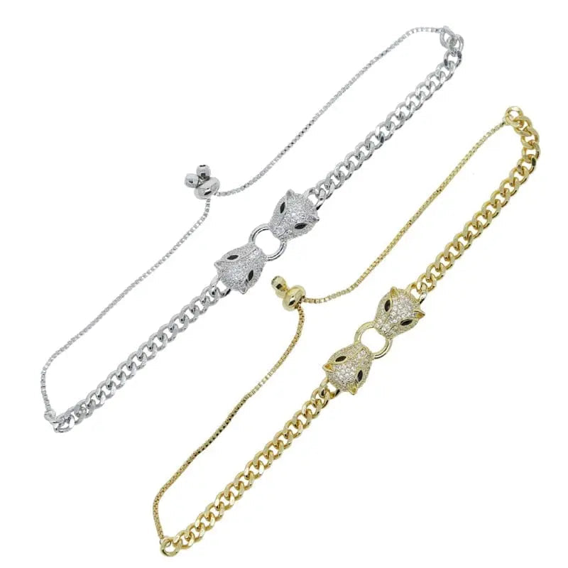Silver and gold-tone Cuban link bracelet featuring double jaguar head designs with black and white CZ stones for women.