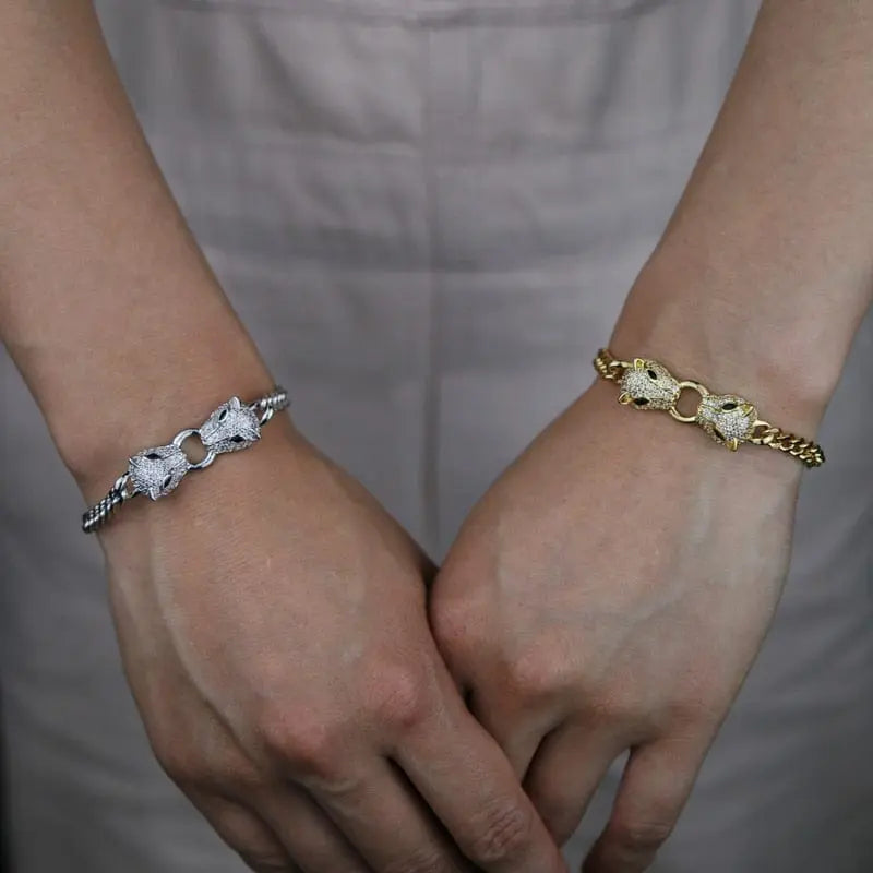 Silver and gold-tone Cuban link bracelet featuring double jaguar head designs with black and white CZ stones for women