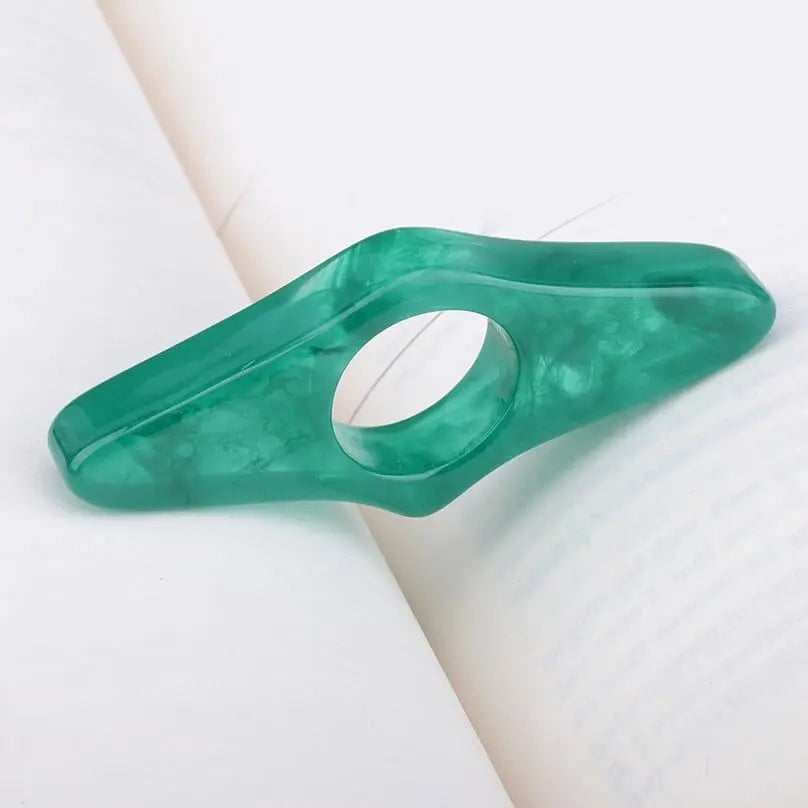 Acrylic thumb book page holder with geometric design, supporting pages for easy reading, in a clear, modern style.