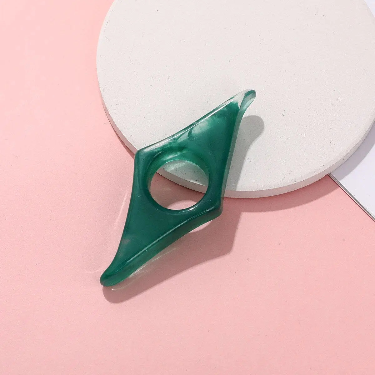 Acrylic thumb book page holder with geometric design, used as a convenient reading support and bookmark for books.
