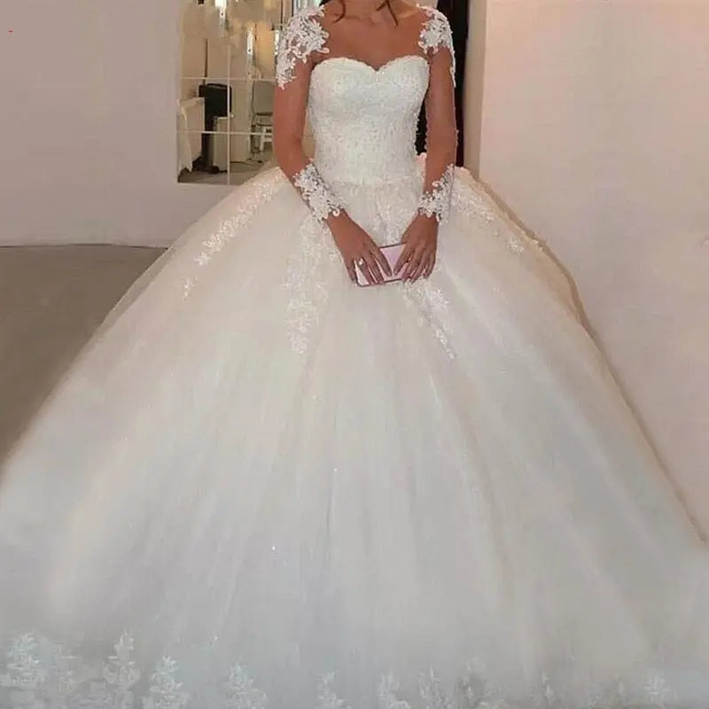 Elegant NUO XI FANG long sleeve tulle wedding gown with a ball gown silhouette, featuring intricate detailing and a modest, beautiful design.
