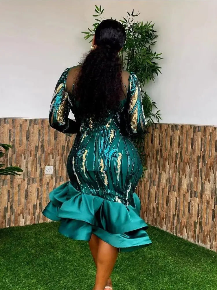 A woman wearing a black sequined mesh sheath dress with three-quarter sleeves, African style evening gown for parties.