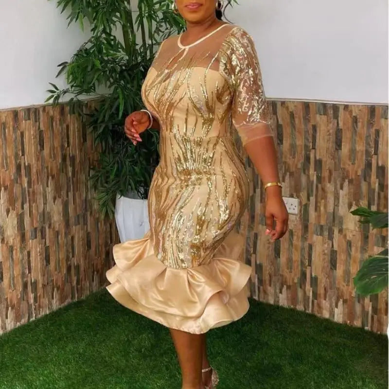 A woman wearing a sequined mesh African-style sheath dress with three-quarter sleeves, perfect for evening celebrations.