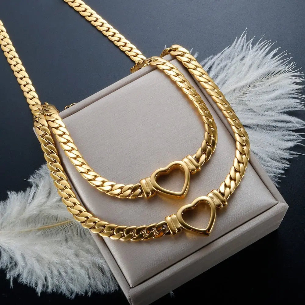 Gold-plated stainless steel heart necklace and nail bracelet set for women, featuring luxury love-themed jewelry.