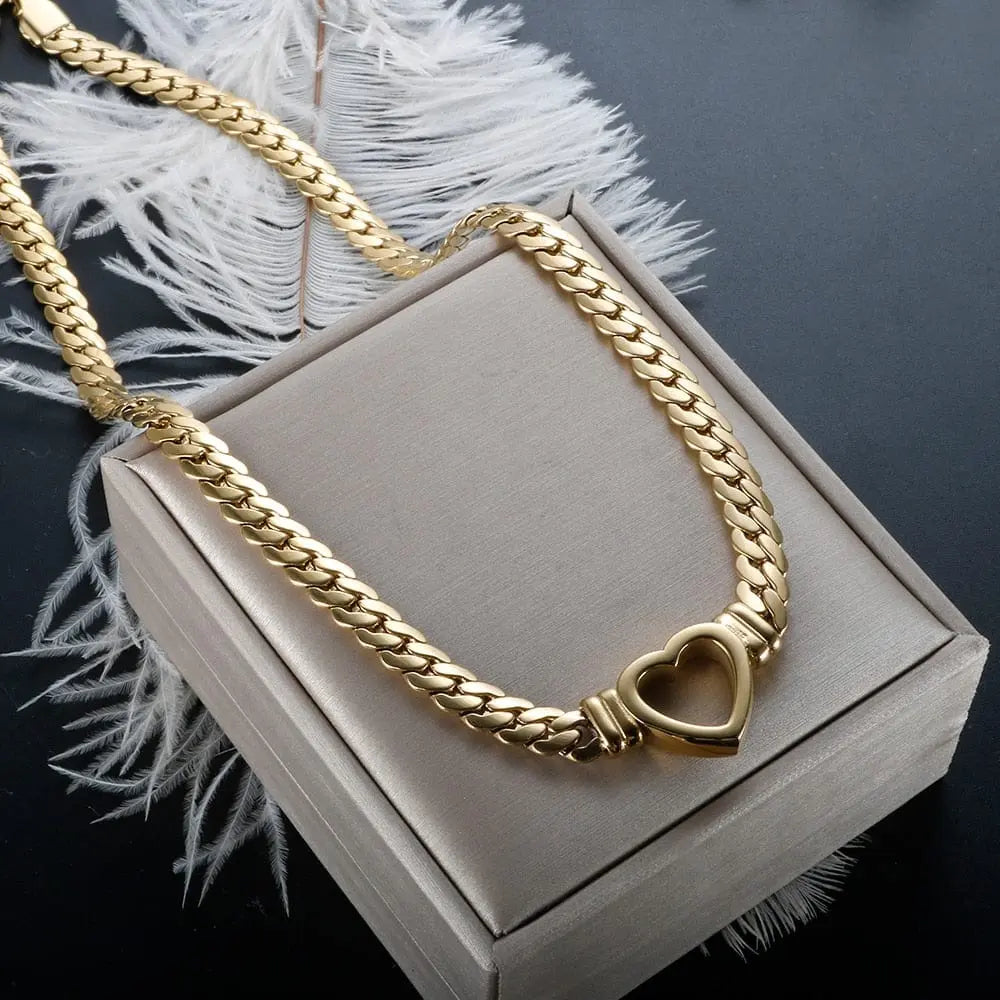 Gold-plated stainless steel heart necklace and nail bracelet set featuring luxury love heart chain jewelry for women.