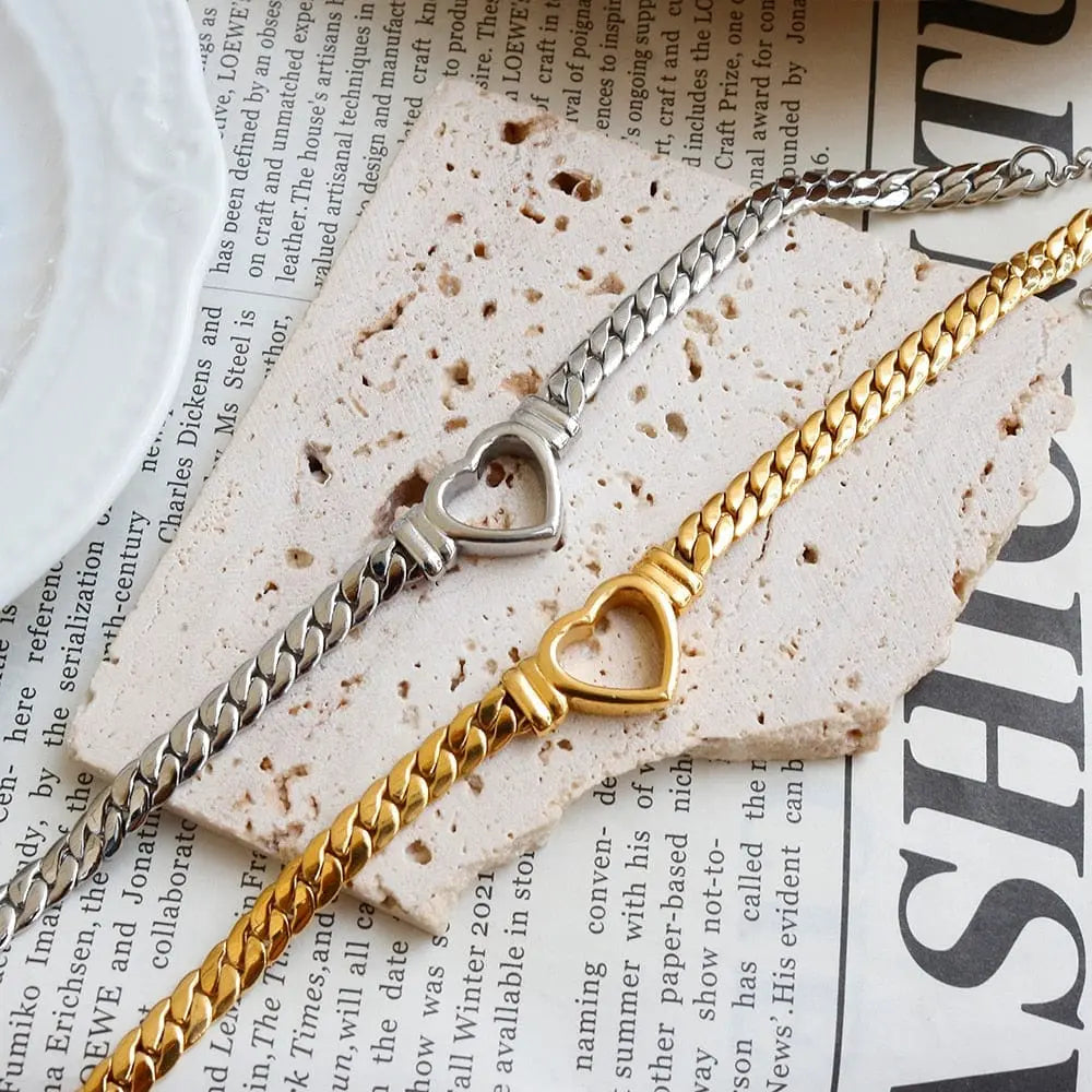 Gold-plated stainless steel heart necklace and nail bracelet set featuring a love heart chain and stylish nail design for women.