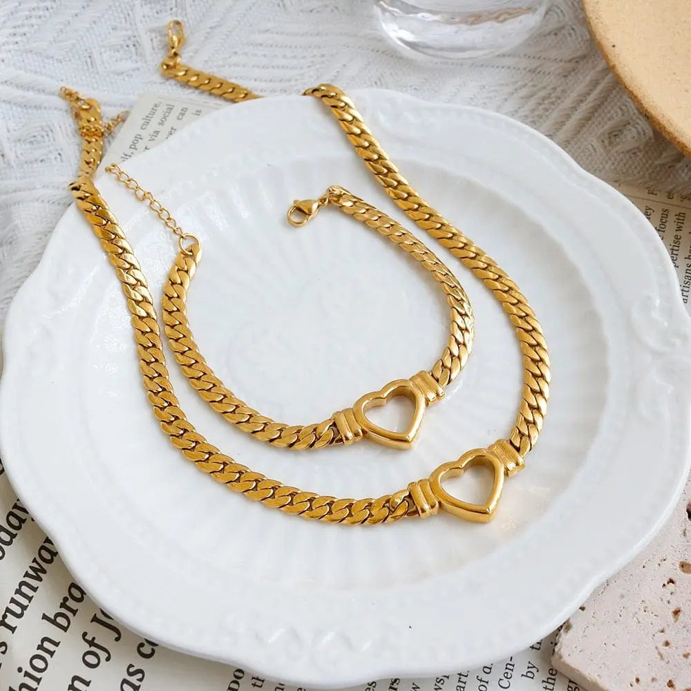 Gold-plated stainless steel heart necklace and nail bracelet set featuring luxurious love heart chain jewelry for women.