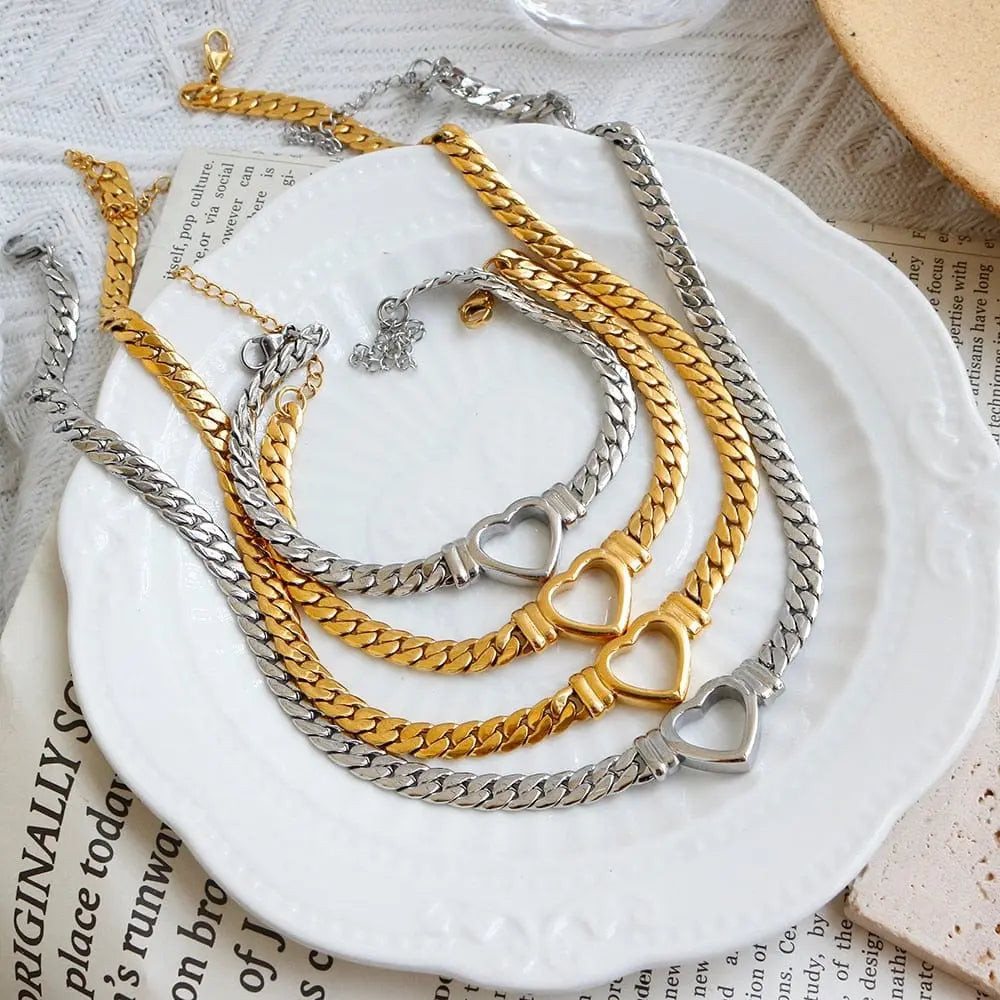 Gold-plated stainless steel heart necklace and nail bracelet set with luxury love design, for women.