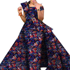 A woman wears a floor-length, off-the-shoulder African print dress with a ruffled bodice.