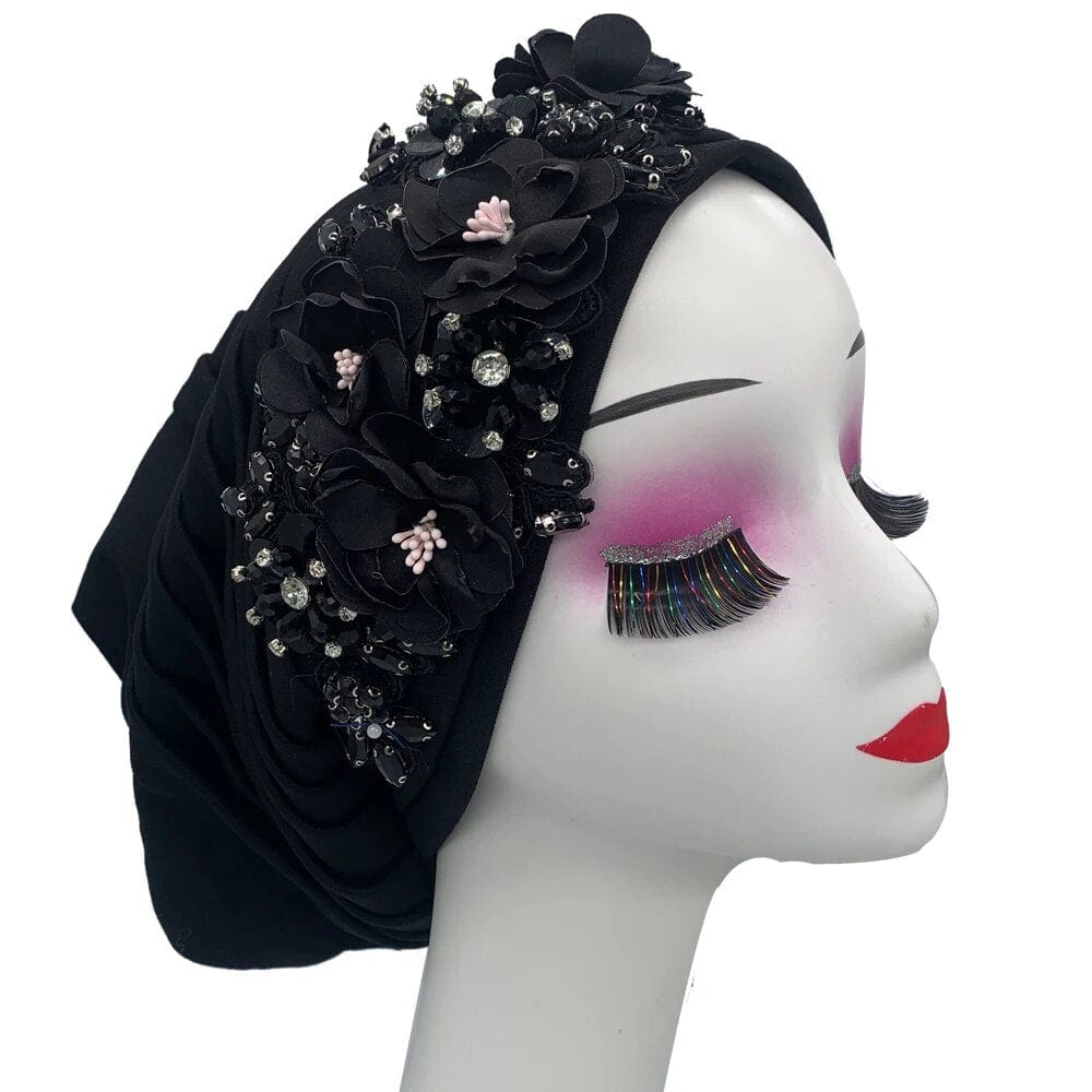 Elegant women's turban cap with flower and diamond embellishments, featuring a Muslim hijab headwear style, worn by a lady.