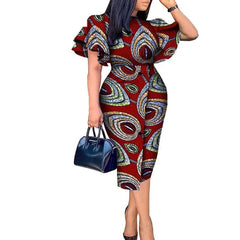 A woman wears a knee-length African wax print dress with butterfly sleeves and a round neckline.