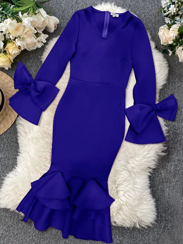 A royal blue bodycon dress with long flared sleeves, bow accents, and a ruffled hem.