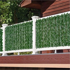 Artificial ivy leaf privacy fence panels installed on a white balcony railing.
