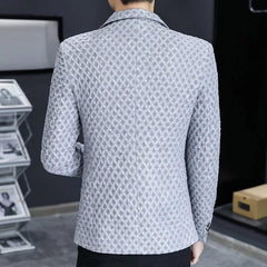 A man wears a slim-fit, light grey blazer with a textured, diamond-patterned fabric.