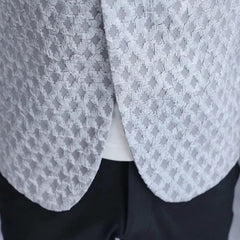 A close-up of a light grey blazer with a textured, grid-like pattern worn over a white shirt.