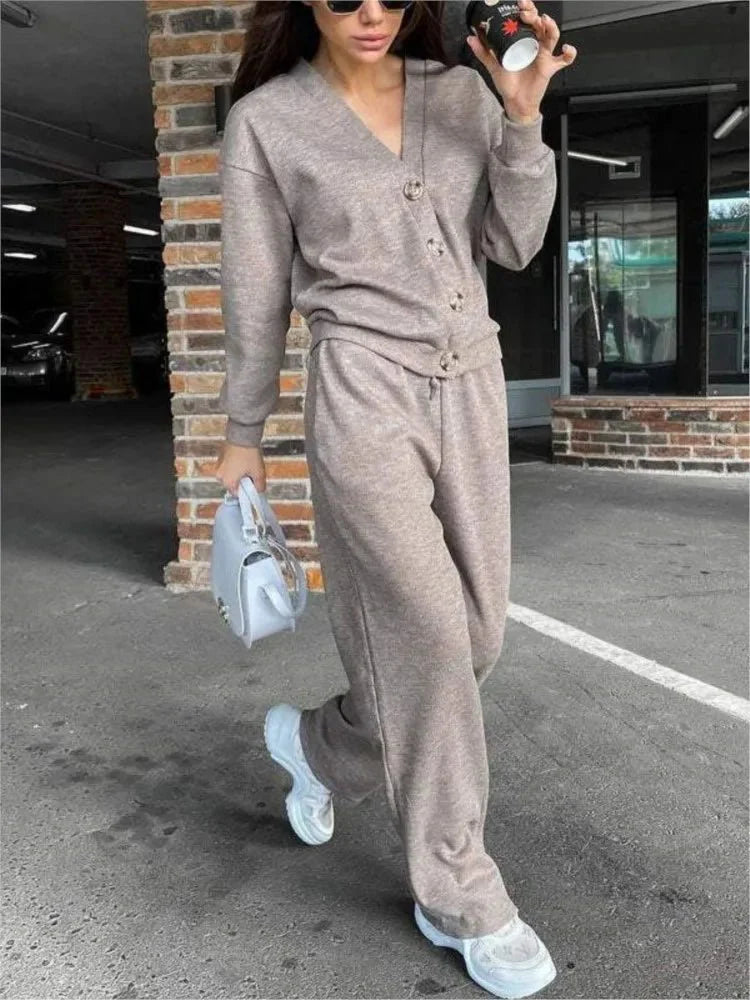 Women's two-piece knit sports suit with single-breasted cardigan and lace-up pants, stylish autumn-winter casual outfit.