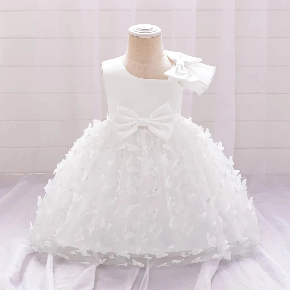 White butterfly tulle baptism and wedding gown for baby girls with a bow, floral accents, perfect for special occasions.