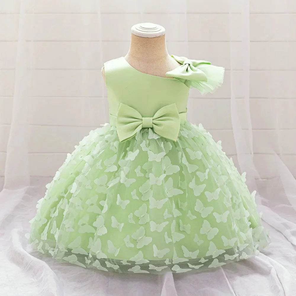 White butterfly tulle baptism and wedding gown for baby girls, featuring a bow, floral accents, and a tutu skirt for special occasions.