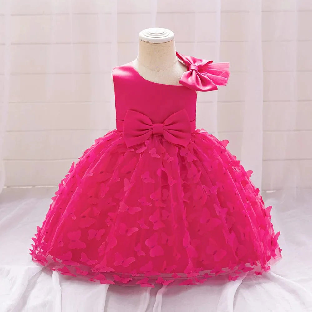 White butterfly tulle baptism and wedding gown for baby girls, featuring a bow, floral accents, and a tutu skirt for special occasions.