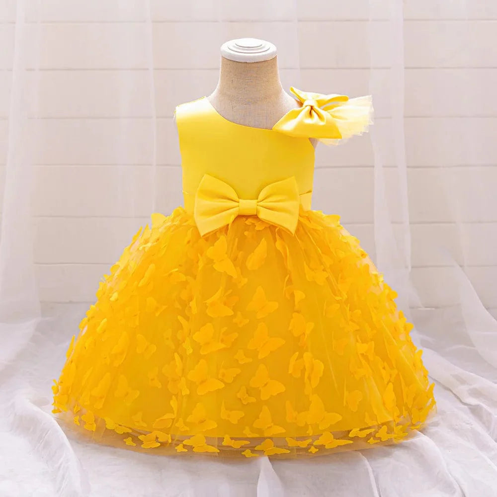 White butterfly tulle baptism and wedding gown for baby girls, featuring a bow, floral accents, and a tutu skirt for special occasions.