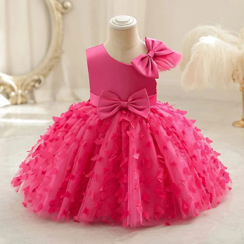 White butterfly tulle baptism and wedding gown for baby girls, featuring a bow and floral accents, perfect for special occasions.