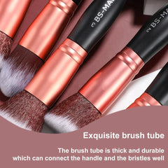 Close-up of makeup brushes featuring black handles and rose gold ferrules with synthetic bristles.