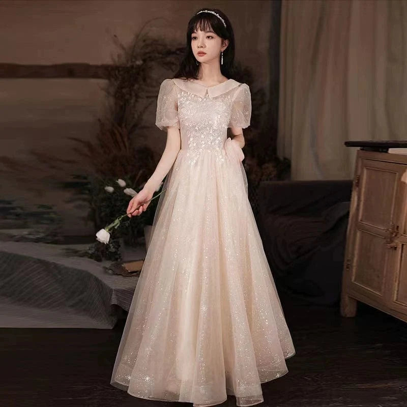 Champagne-colored Showlu Fashion evening gown with intricate embroidery, mid-length style perfect for elegant events.