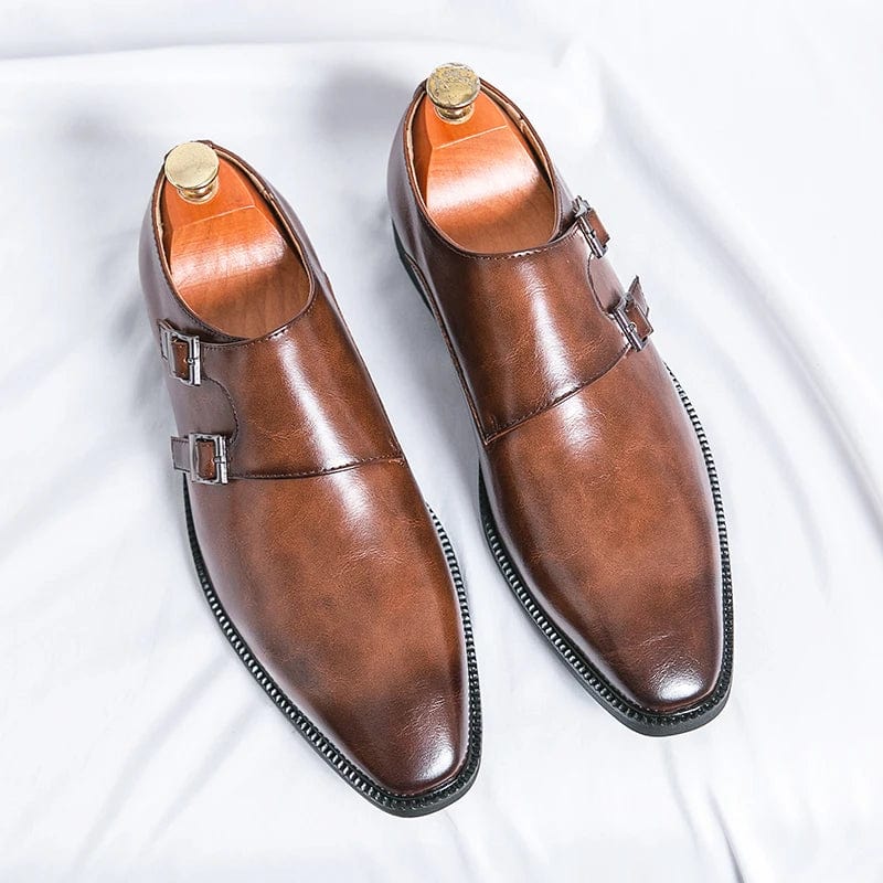 Men's black leather monk strap shoes with pointed toe and buckle, designed for business and formal occasions.