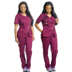 A woman wears a burgundy scrub set featuring a side-zip top and matching pants.