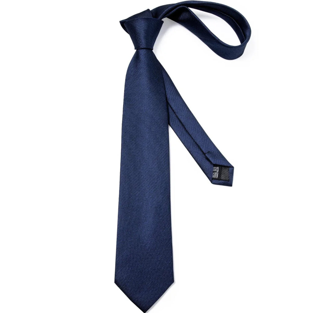 Navy blue solid silk tie set for men including necktie, cufflinks, and matching pocket square, perfect for business or weddings.