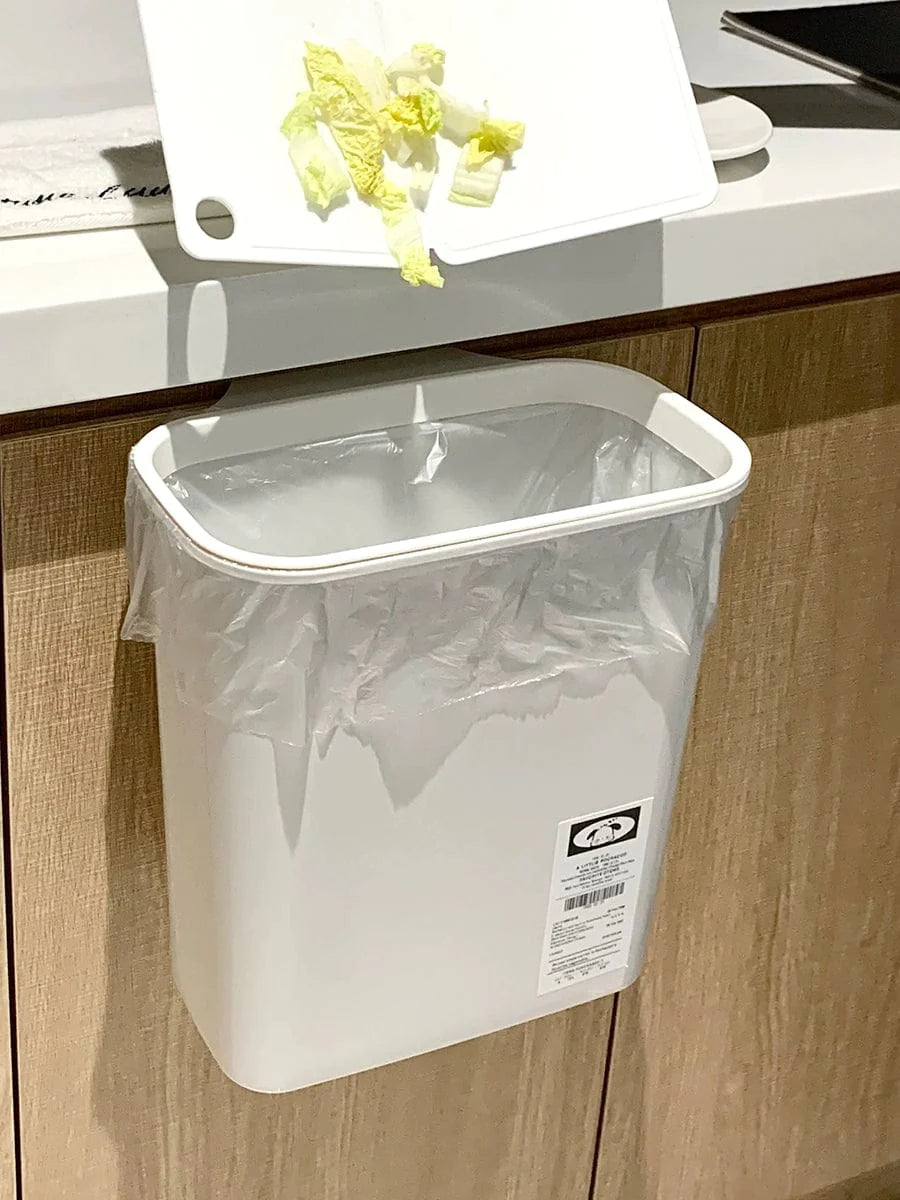 Wall-mounted Donha 4L plastic kitchen trash can hanging on a cabinet door for convenient waste disposal.