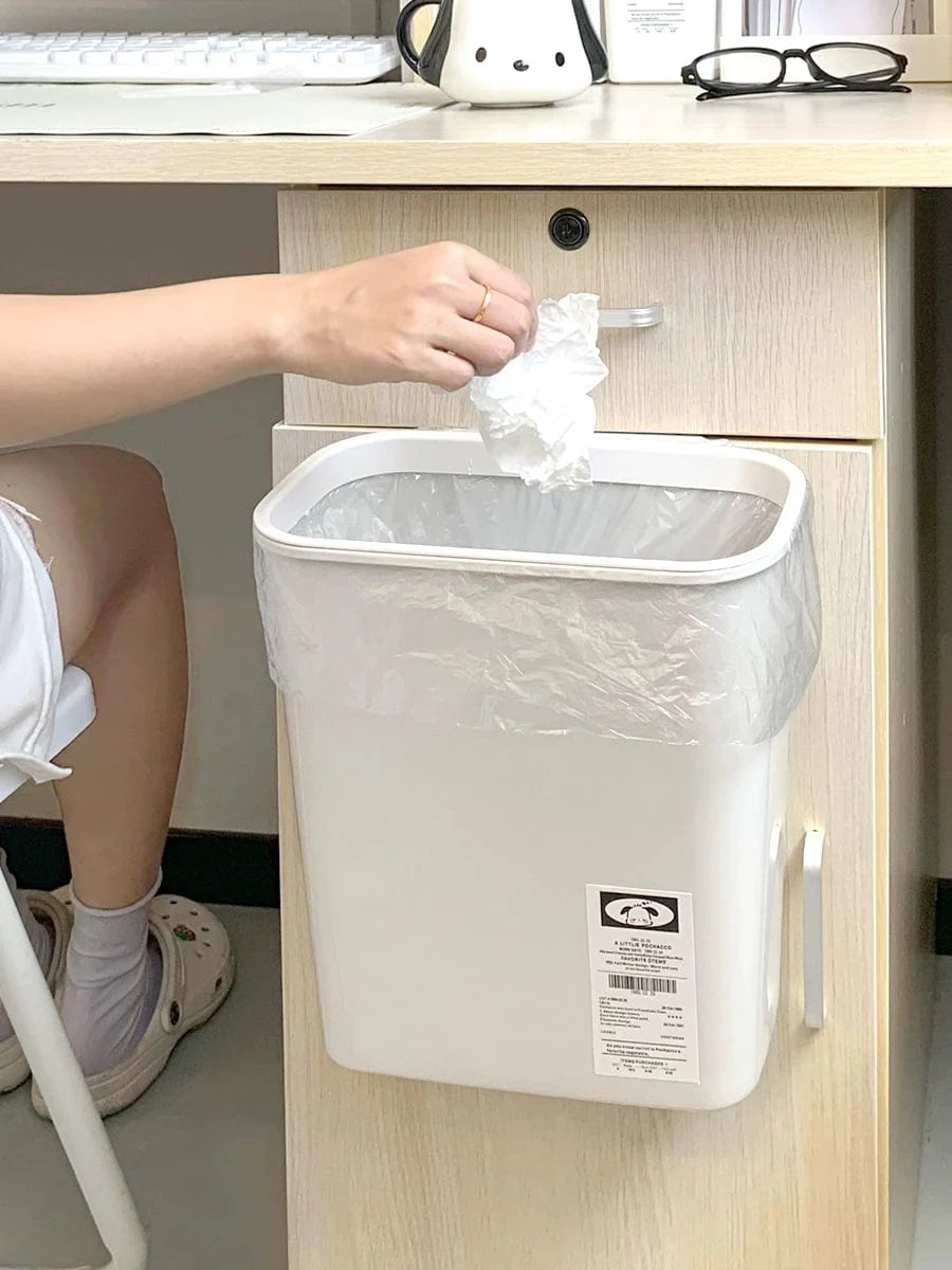 Donha wall-mounted kitchen trash can in white plastic with 4L capacity, hanging on a cabinet door for easy waste disposal.